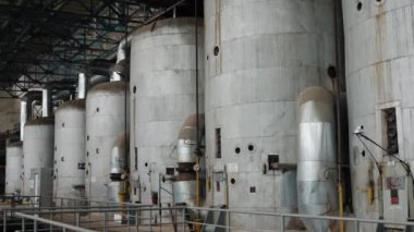 Depolama tankları, metal tanklar, fabrika ortamı. Erişilebilirlik ve karmaşık borular için merdivenlerle dolu devasa metal depolama tankları, sanayi fabrikalarının hakimi..
