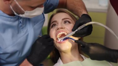 Diş aletleri, diş muayenesi, ağız bakımı. Hasta gülümsemesi dişçi ve asistan olarak çeşitli araçlarla diş tedavisi uygular.