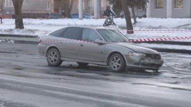 Araba kazası, trafik kazası, tehlikeli kaza. Araba, önden ağır hasar görmüş, tehlikeli bantlarla korunuyor..