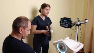 El rehabilitasyonu, klinik rehabilitasyon, terapist rehberliği. Hasta, terapistin rehberliğinde yenilikçi direksiyon aygıtı kullanarak el ve kol rehabilitasyon egzersizleri yapıyor.
