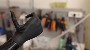protez el, karbon fiber, siyah eldiven. Karbon fiberden yapılmış protez elin yakın plan görüntüsü, siyah eldivenle kaplı, doğal dinlenme pozisyonu, gelişmiş protez teknoloji