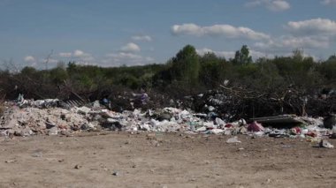 Atık yönetimi, çöp sorunu, arazi kirliliği. Atık yığınlarıyla dolu geniş alanlar, acil reform gereksinimini vurgulayarak, atık yönetim sistemlerinin korkunç çevresel durumu gösteriyor.