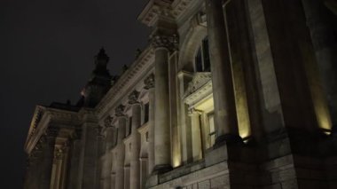 Tarihi Reichstag, bayrak sergisi, aydınlanmış bayraklar. Almanya parlamentosuna ev sahipliği yapan Reichstag, bayraklarla çevrili, geceleri ışıl ışıl parlıyor.