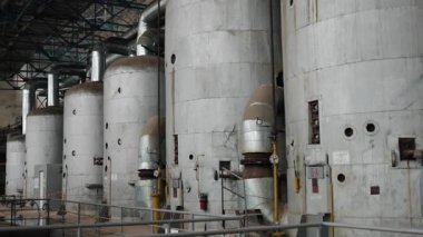 Erişim merdivenleri, tank altyapısı, fabrika kapasitesi. Endüstriyel fabrika evlerinde büyük metal depolama tankları var. Her birinde erişim merdivenleri ve ağ boruları var..