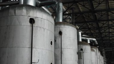 Metal tanklar, tanklar, endüstriyel aralıklar. Boru ve kanallarla donatılmış büyük metal tanklar serisi, iç hatları geniş endüstriyel kompleks.