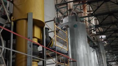 Endüstriyel merdivenler, kompleks yerleşim, iç karmaşıklık. Endüstriyel tesisin içinde karmaşık boru, merdiven ve metal tanklar var..