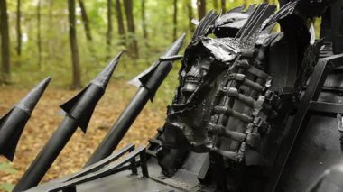 Zırhlı araç, çivili zırh, sert metal. Yakın plan, ağaçlık alanda ağır zırhlı, çivili bir araç gösteriyor. Kıyameti andıran ya da sert metal detaylarıyla çarpışmaya hazır bir tasarım..