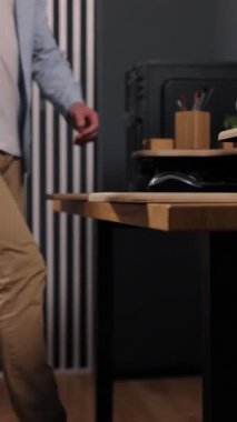 Masa başı bakış açısı, modern masa, organize ofis. Yan görüşlü adam masaüstü bilgisayarı, monitörü ve bambu organizatörleriyle modern ahşap masada oturuyor. dikey