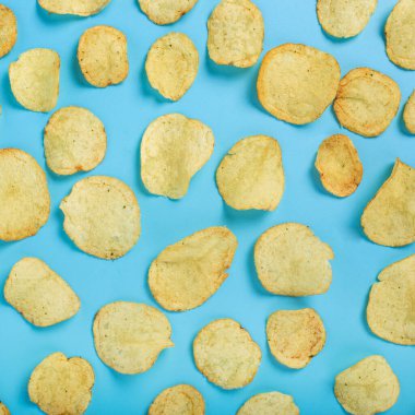 Mavi arka planda taze patates cipsi hazırlayın. Üst manzara, düz uzanma