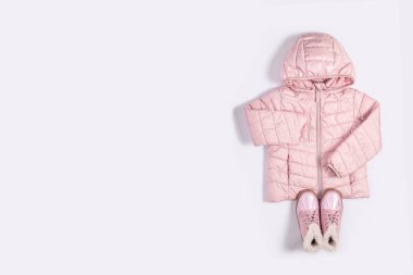 Beyaz arka plandaki bir kız için çocuk ceketi ve botları. Üst manzara, düz uzanma