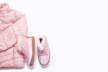 Beyaz arka plandaki bir kız için bebek ceketi ve botları. Üst manzara, düz yatış. Pankart