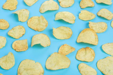 Mavi arka planda taze patates cipsi hazırlayın. Üst manzara, düz uzanma