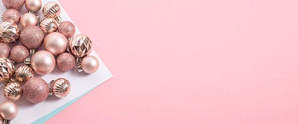 stock image Beautiful shiny pink decorative balls on a pink background. Top view, flat lay. Banner