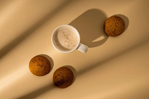 Coffee, oatmeal cookies on a beige background. Flat lay, top view