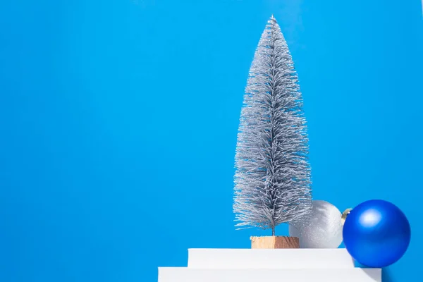 Vánoční Stromek Dekorativní Koule Bílém Pódiu Modrém Pozadí — Stock fotografie