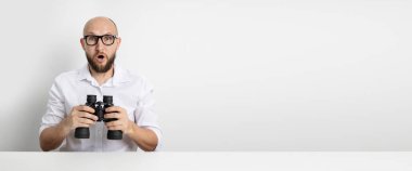 Beyaz arka planda dürbünlü genç adam şaşırdı. Pankart.