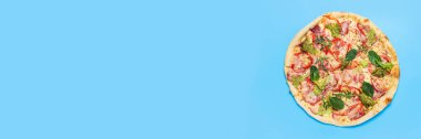 Pizzanın sıcaklığı mavi arka planda. Üst manzara, düz yatış. Pankart.