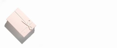 Nazikçe pembe hediye paketi beyaz arka planda. Üst manzara, düz yatış. Pankart.