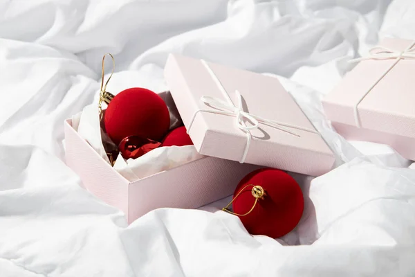 Caixas Presente Com Brinquedos Natal Decorativos Vermelhos Tecido Branco Amassado — Fotografia de Stock