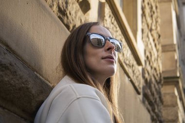 Smiling young girl with glasses outdoors in the city.