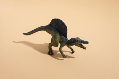 Plastik oyuncak dinozor arka planda.