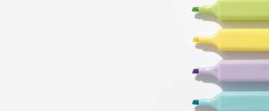 Beyaz arka planda renkli kalemler. Üst manzara; düz yatış. Pankart.