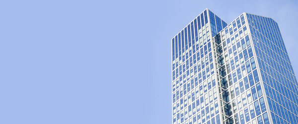 Skyscraper against a blue sky without clouds. Banner.