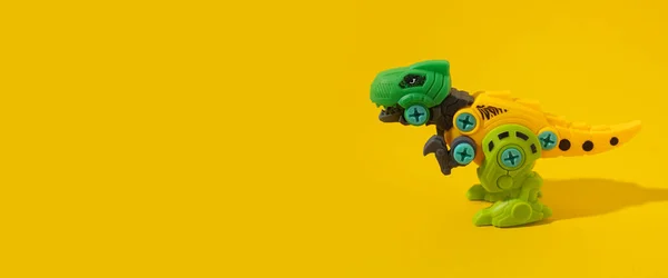 黄色の背景にプラスチック恐竜のおもちゃ バナー — ストック写真