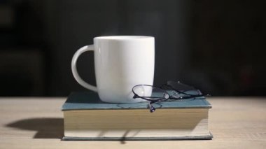 Kitap, kahve ve bardaklar. Dar odak.