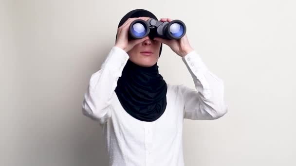 若いです女性でHihab見を通して双眼鏡上の白い背景 — ストック動画