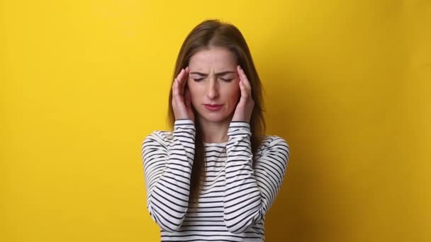 黄色の背景で頭痛に苦しんでいる若い女性 — ストック動画