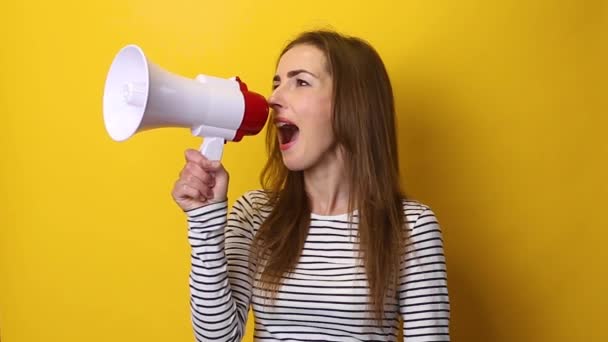 Jonge Vrouw Spreekt Een Megafoon Een Gele Achtergrond — Stockvideo