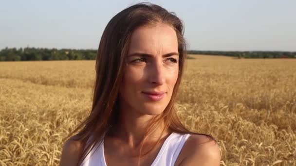 Ung Kvinna Framför Ett Vetefält Vid Solnedgången — Stockvideo