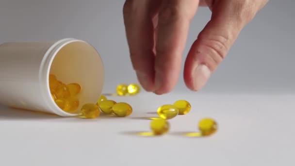 Erkek Beyaz Arka Planda Sarı Bir Vitamini Kapsülü Alır — Stok video