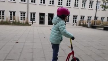 Motosiklet süren kasklı küçük kız.
