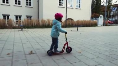 Motosiklet süren kasklı küçük kız.