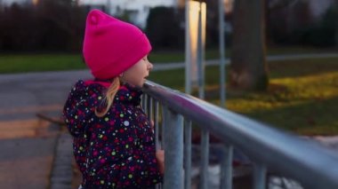 Çocuk kız gölün kenarında duruyor..