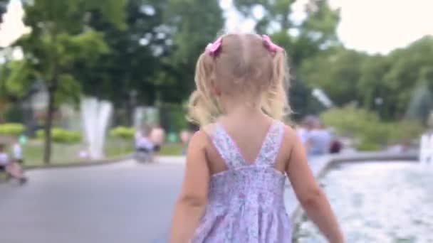 小女孩走在公园的喷泉边 — 图库视频影像