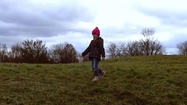 穿着夹克的小女孩在公园斜坡上散步 — 图库视频影像