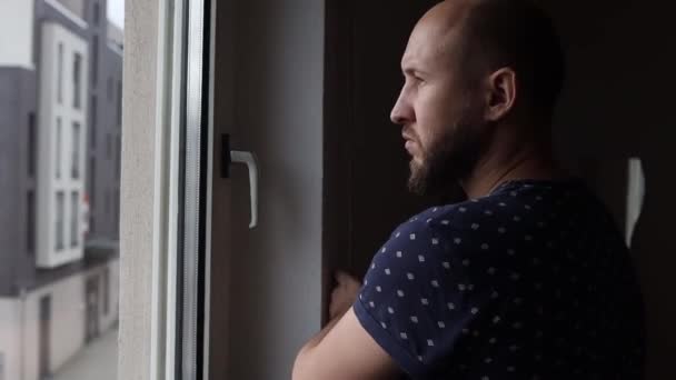 Unge Man Tittar Genom Fönstret Och Stänger Fönsterluckan — Stockvideo