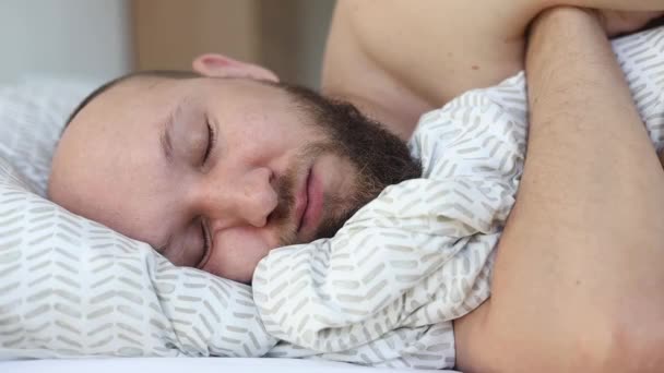 髭を生やした若者がベッドで寝ている — ストック動画