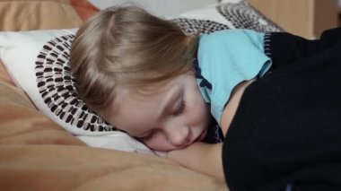 Yatakta battaniyenin altında uyuyan kız çocuğu. Uyku kavramı, gündüz uykusu..