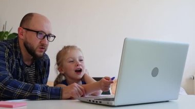 Babası kızının internetten ödevlerini yapmasına yardım ediyor.