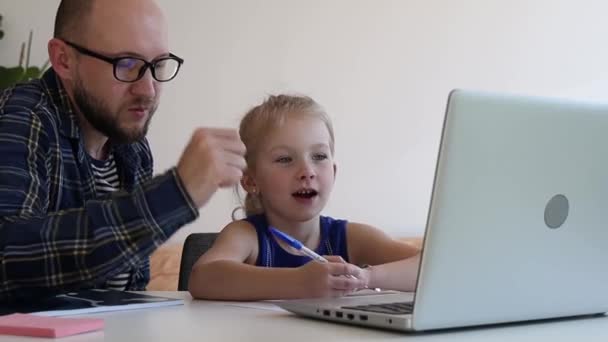 お父さんは娘がオンライン学校から宿題をするのを助ける — ストック動画