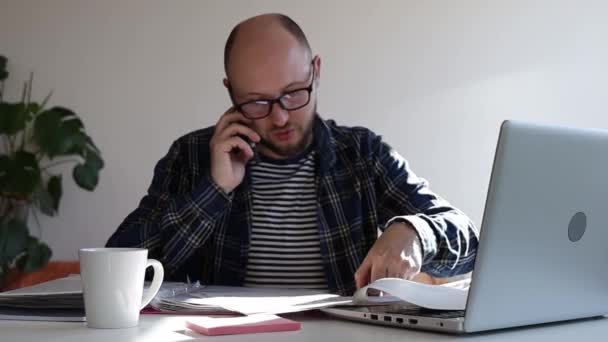Man Met Een Bril Aan Telefoon Het Sorteren Van Documenten — Stockvideo