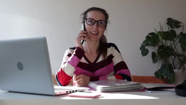 電話で話して家で働いてる女性 — ストック動画