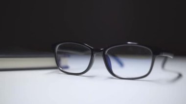 Siyah çerçeveli bardaklar masanın üzerinde, ışığı değiştiriyor..