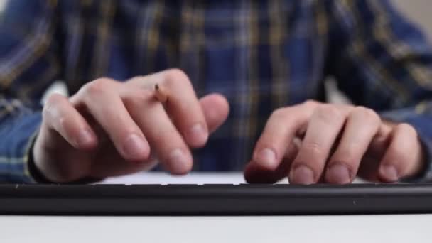 一个男人坐在桌子旁 一边打字一边用铅笔写字 — 图库视频影像