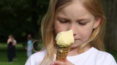 Parkta dondurma yiyen kız.