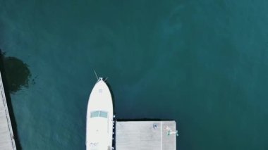 Tekneler ve yatlarla deniz koyunun drone görüntüsü.